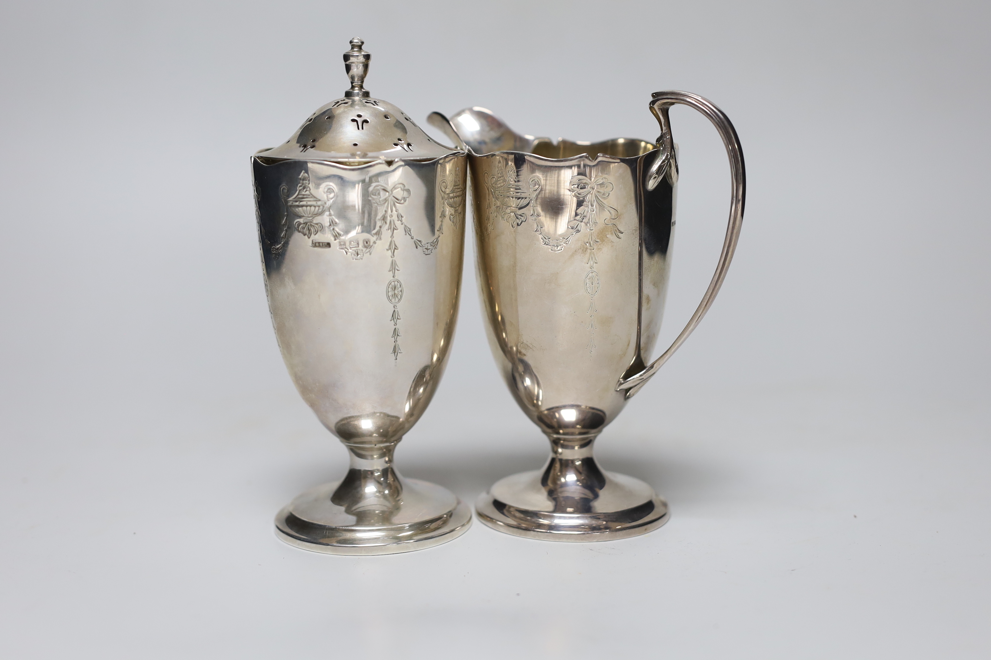A George V chased silver cream jug and matching sugar caster, Collingwood & Sons Ltd, Birmingham, 1913, caster 15.7cm, 12.2 oz.